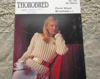 May include: A vintage magazine cover featuring a woman wearing a cream-colored, pure wool sweater with ribbed sleeves and a gold belt. The text reads "THOROBRED" and "Pure Wool Brushed 454". The sweater is designed for a chest size of 80-100 cm.