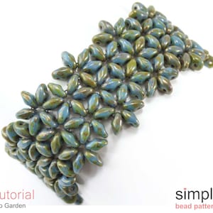 Könnte beinhalten: Ein blaugrünes und goldenes Armband mit Blumenmuster. Das Armband ist aus Perlen gefertigt und ein einfaches Perlenmuster.