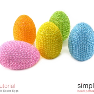 Puede incluir: Cinco huevos de Pascua de cuentas en diferentes colores: rosa, amarillo, verde, naranja y azul. Los huevos est&aacute;n dispuestos en una fila sobre un fondo blanco.