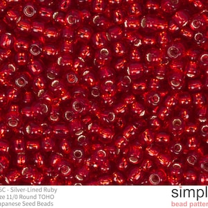 May include: Close-up of a pile of silver-lined ruby red Japanese seed beads. The beads are size 11/0 and round. The image includes the text "# 25C - Silver-Lined Ruby Size 11/0 Round TOHO Japanese Seed Beads".