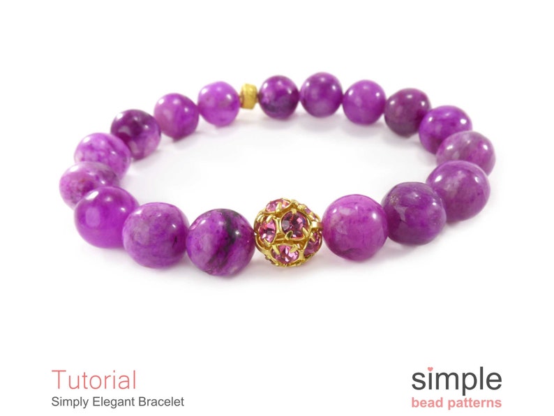 Op de afbeelding: Een armband van paarse edelstenen met een gouden en roze kristallen kralenbedel. De armband is gemaakt met ronde, gladde kralen.