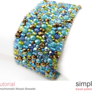 May include: A blue, green, and gold beaded bracelet made with a mosaic bead pattern. The bracelet is made with small seed beads and is a simple design.