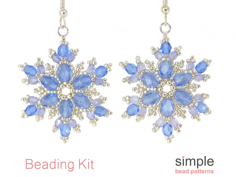 May include: A pair of snowflake-shaped earrings. Each earring features a central design of light blue oval beads surrounded by smaller, lighter blue and silver beads. The earrings are suspended from silver hooks. The text "Beading Kit" and "simple bead patterns" are visible.