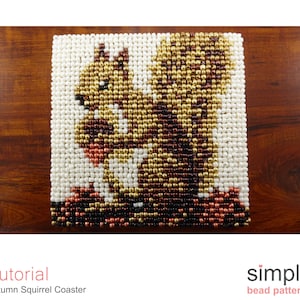 Może przedstawiać: Podkładka pod kubek z koralików w kształcie wiewiórki w brązowych, złotych i białych kolorach. Wiewiórka trzyma żołędź w łapkach. Podkładka jest wykonana z małych koralików i idealnie nadaje się do dodania odrobiny fantazji do wystroju domu.