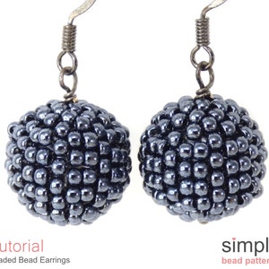 May include: A pair of beaded earrings in a dark grey, almost black, colour. The earrings are made of small beads clustered together to form a sphere shape. The earrings are attached to silver-toned ear wires.