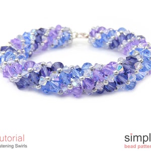 May include: A purple, blue, and silver beaded bracelet with a silver clasp. The bracelet is made with small, faceted beads in a swirling pattern.