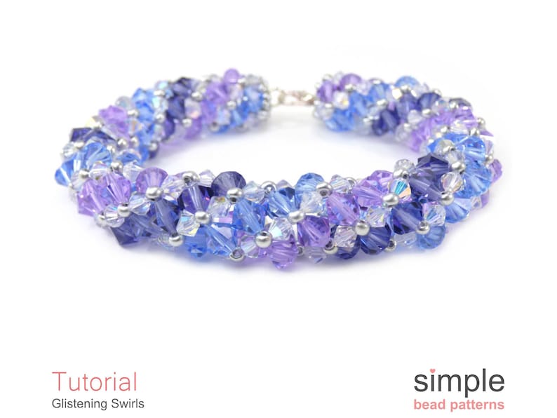 May include: A purple, blue, and silver beaded bracelet with a silver clasp. The bracelet is made with small, faceted beads in a swirling pattern.