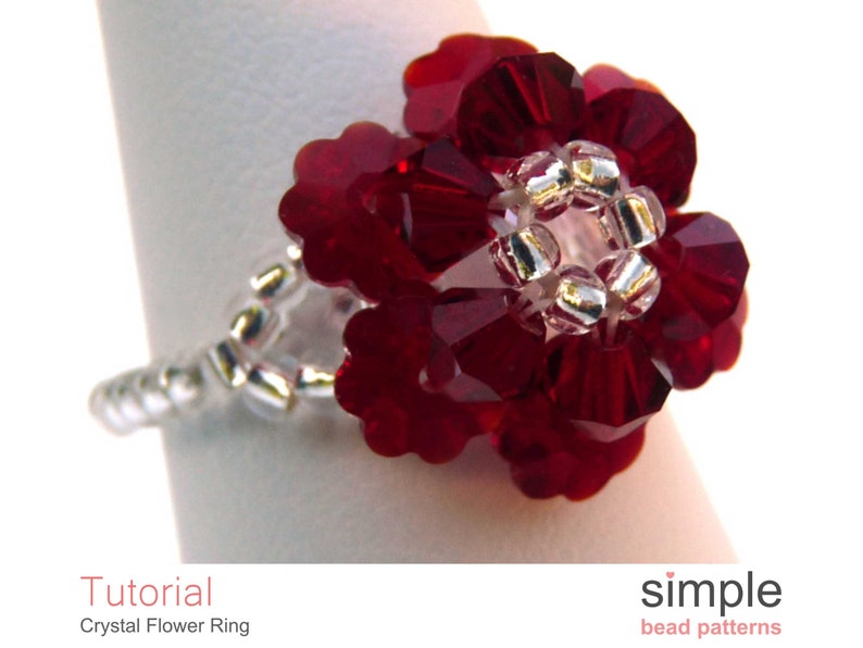 May include: A red crystal flower ring with silver beads. The ring is on a white background. Tutorial: Crystal Flower Ring. simple bead patterns.