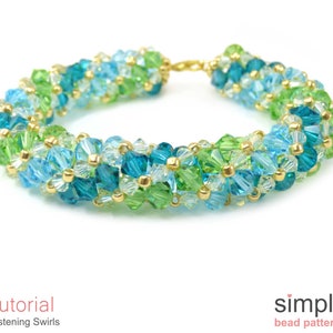 May include: A beaded bracelet with a gold clasp, featuring a swirling pattern of green, blue, and clear beads.
