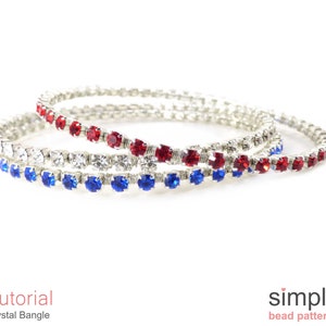 Könnte beinhalten: Drei silberne Armreifen mit roten, weißen und blauen Kristallverzierungen. Die Armreifen sind übereinander gestapelt. Der Text "Tutorial Crystal Bangle" und "simple bead patterns" ist unterhalb der Armreifen sichtbar.