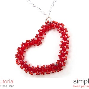 Może przedstawiać: Naszyjnik z czerwonym sercem z koralików. Serce jest wykonane z małych czerwonych koralików i jest otwarte w środku. Naszyjnik jest na srebrnym łańcuszku.