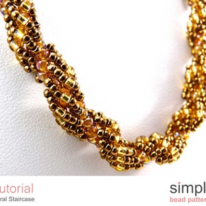 Puede incluir: Primer plano de un collar de cuentas doradas con un diseño de escalera de caracol. El collar está hecho con cuentas pequeñas y redondas y tiene un brillo sutil. Las cuentas están dispuestas en un patrón retorcido, creando un efecto tridimensional. El collar es un hermoso ejemplo de trabajo con cuentas y sería un accesorio único y elegante.