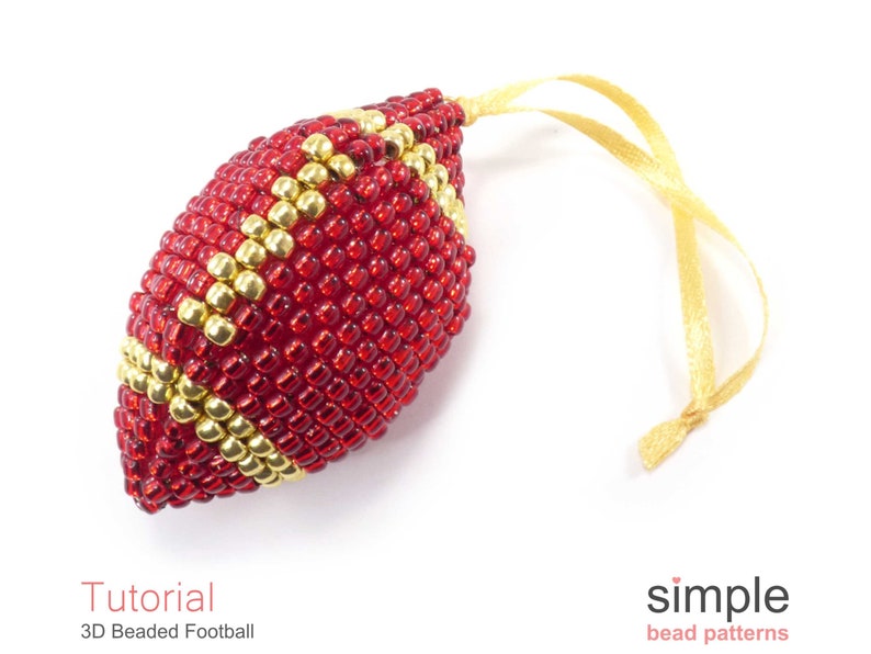 May include: A red and gold beaded football ornament with a gold ribbon for hanging. The ornament is a 3D beaded design and is a tutorial for a 3D beaded football.