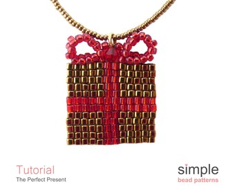 May include: A gold chain necklace with a red and gold beaded gift box pendant. The gift box has a red bow on top.