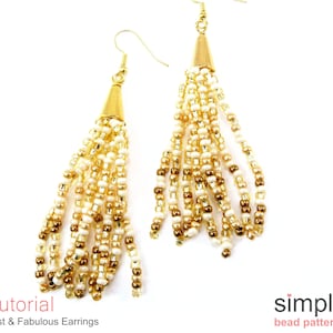 May include: Gold tone earrings with a tassel of white and gold beads. The earrings are a simple design and would be a great addition to any jewelry collection.