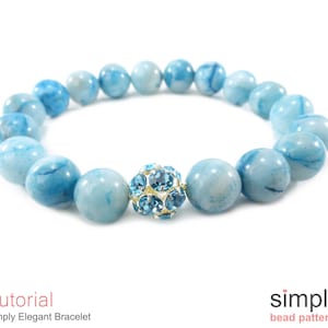 Op de afbeelding: Een lichtblauwe armband met een kristallen accent. De armband is gemaakt van ronde kralen met een marmerpatroon.