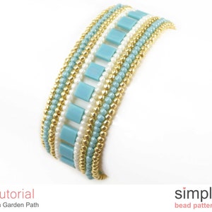 May include: A beaded bracelet featuring a pattern of gold, white and light blue beads. The bracelet is crafted with small, round beads and larger, square beads. The bracelet is called "Tila Garden Path" and is a "simple bead pattern".
