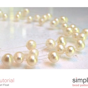 May include: A close-up of a pearl necklace with a simple design. The pearls are white and round, and they are strung on a clear thread. The necklace is lying on a white surface.