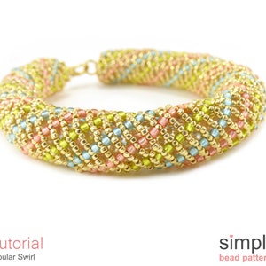 May include: A gold, pink, blue and green beaded bracelet with a tubular swirl design. The bracelet is made with small seed beads and is a simple bead pattern.