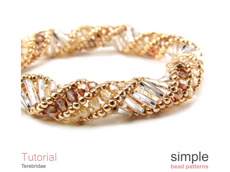 以下が含まれることがあります： ねじれたデザインのゴールド、ブラウン、クリアビーズのブレスレット。ブレスレットは、小さな丸いビーズと長い長方形のビーズで作られています。ブレスレットは白い背景の上にあります。