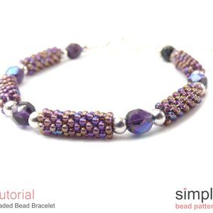 May include: A purple and silver beaded bracelet with a simple design. The bracelet is made with small seed beads and larger faceted beads. The bracelet is a great example of a simple beading project.