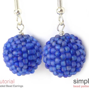May include: A pair of blue beaded earrings with silver ear wires. The beads are small and round, creating a spherical shape. The earrings are a simple and elegant design.