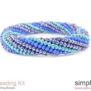 May include: A beaded bangle bracelet kit in shades of blue, teal, and purple. The kit includes all the beads and instructions needed to create a swirling bangle bracelet.