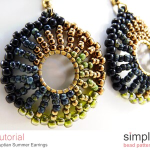 May include: A pair of gold, green, and black beaded earrings with a circular design. The earrings are handmade and feature a variety of bead sizes and shapes.