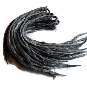 May include: A bundle of black and grey wool dreadlocks. The dreadlocks are approximately 61 cm long and are made of 100% wool.