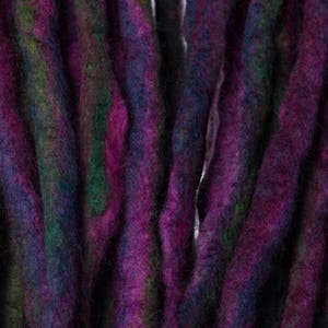 May include: Close-up of a bundle of purple, green, and blue wool dreadlocks.
