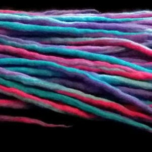 May include: A bundle of colorful wool dreadlocks in shades of pink, purple, blue, and teal.