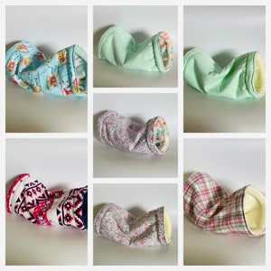 May include: Six pet tunnels in a variety of patterns and colours. Designs include a light blue llama print, solid mint green, floral patterns, and a pink and white geometric design. Each tunnel has a soft, plush interior.