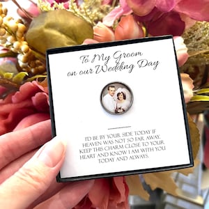 Peut inclure: Une carte blanche avec du texte noir qui dit "To My Groom on our Wedding Day." La carte est dans une boîte noire et présente un petit charme rond en argent avec une photo en noir et blanc d'un couple le jour de son mariage.