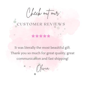 May include: A graphic with text that reads "Check out our CUSTOMER REVIEWS." The text is on a pink watercolour background with five pink stars. The text below reads "It was literally the most beautiful gift."