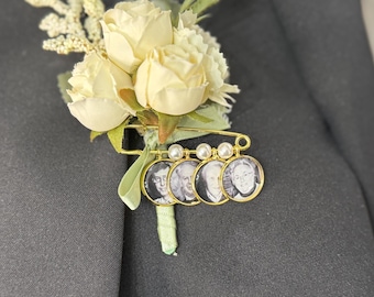 May include: A gold brooch with four small round portraits of people, surrounded by white pearls. The brooch is attached to a white flower corsage.