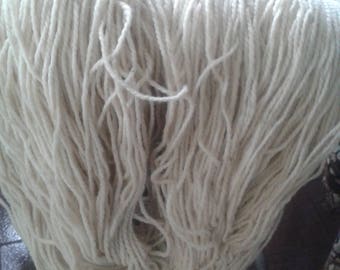 May include: A large bundle of white yarn, likely cotton, is piled on a chair. The yarn is soft and fluffy, and it appears to be ready for knitting or crocheting.