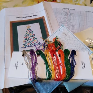 Un kit con un biglietto ripiegabile in tre con albero di Natale astratto punto croce su 18 punti
