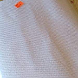 May include: White Aida cloth for cross stitch, measuring 11 x 12 inches.