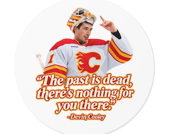 May include: A circular sticker featuring a hockey goalie wearing a white, red, and yellow jersey with a flaming C logo and a goalie mask. Below the goalie, the text reads: "The past is dead, there's nothing for you there." -Devin Cooley.