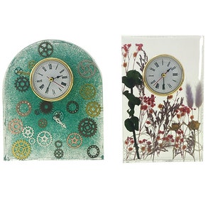 Peut inclure: Deux horloges décoratives avec des designs différents. La première horloge a un fond vert avec des engrenages dorés et un cadran blanc. La deuxième horloge a un fond transparent avec des fleurs séchées et un cadran blanc.