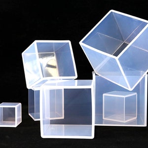May include: Five clear plastic cube molds of varying sizes. The molds are stacked on top of each other.