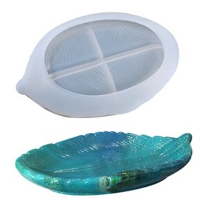 May include: A clear silicone mold shaped like a leaf with four sections. The mold is shown next to a teal blue leaf-shaped resin tray.
