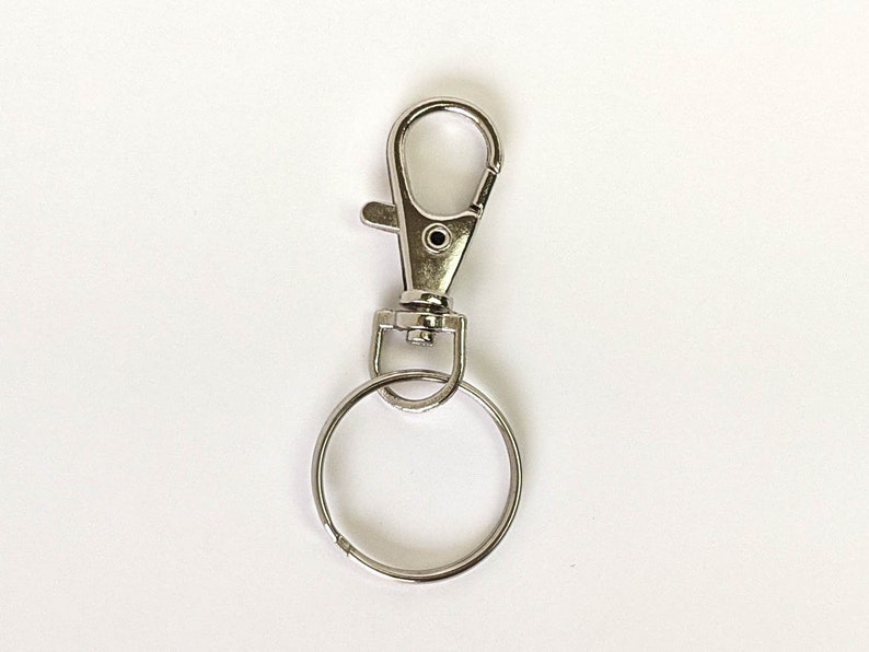 May include: Silver key chain with a swivel clasp and a round ring.
