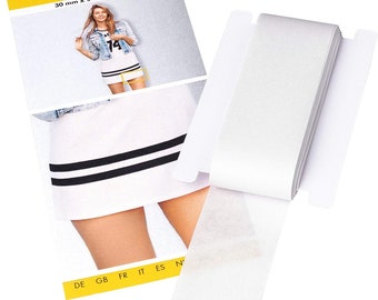 May include: A white roll of Stretchfix T30 fabric adhesive tape, 30 mm wide and 5 metres long. The tape is 100% polyurethane and is shown on a white background with a yellow label that says "Stretchfix T30" and "30 mm x 5 m 100% PU".