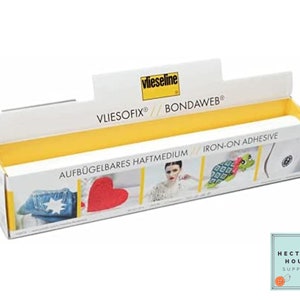 May include: A white box with yellow accents and the text "Vliesofix® Bondaweb®" on the front. The box contains a roll of iron-on adhesive. The text "Aufbügelbares Haftmedium Iron-on Adhesive" is printed on the box.