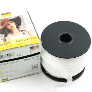May include: A spool of white bias tape labelled "FORMBAND BIAS TAPE T12 12 mm x 100 m 100% PA".