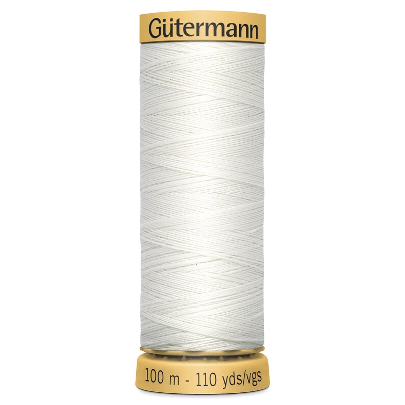 May include: A spool of white sewing thread by G&uuml;termann. The spool features a tan top label with the brand name and a tan base label displaying the length as 100 m - 110 yds/vgs. The white thread is wound in a cross-hatch pattern around the cylinder.