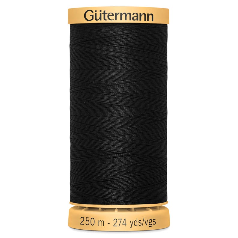 May include: A spool of black sewing thread with a tan plastic top and bottom. The top label reads G&uuml;termann in black text. The bottom label displays the length as 250 m - 274 yds/vgs. The thread is wound in a cross-hatch pattern around the cylinder.
