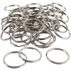 Könnte beinhalten: Ein Haufen silberner Schlüsselringe. Die Schlüsselringe sind alle gleich groß und aus Metall.