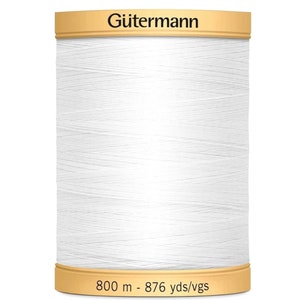 May include: A spool of white sewing thread by G&uuml;termann. The top label displays the brand name G&uuml;termann in black text. The bottom label indicates a length of 800 m - 876 yds/vgs. The thread is wound tightly around the cylindrical spool core.